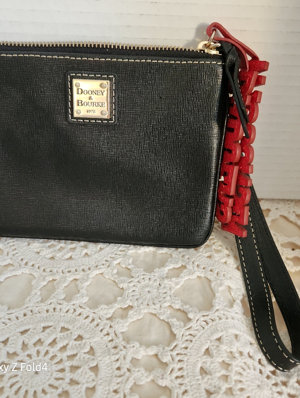 Dooney & Bourke Black Leather Wristlet with Red Tassel Accent